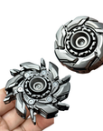 Two metallic fidget spinners held by a hand on a white background